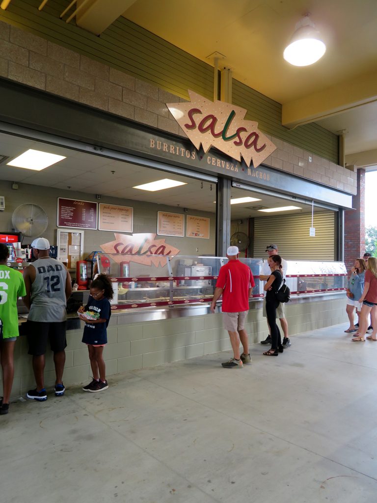 People wait in line at a concession stand called "Salsa."