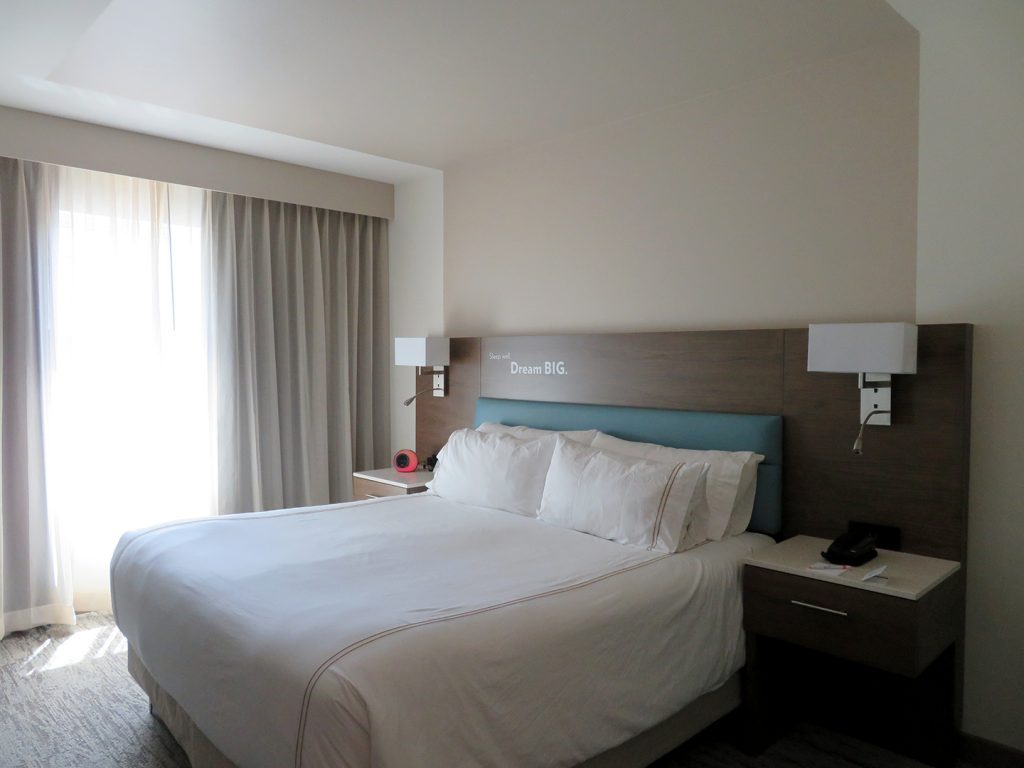 Diagonal view of a king-size bed with nightstands on each side at the EVEN Hotel Eugene.