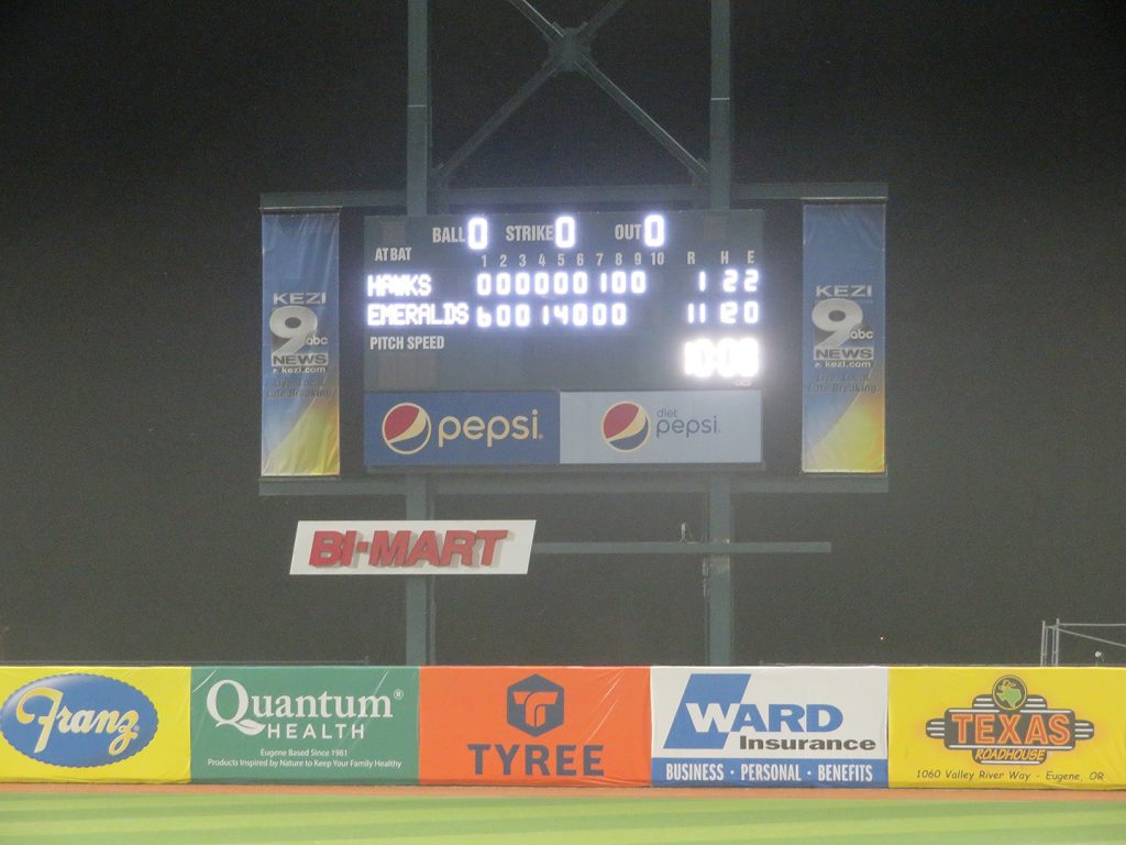 Scoreboard over an outfield fence.