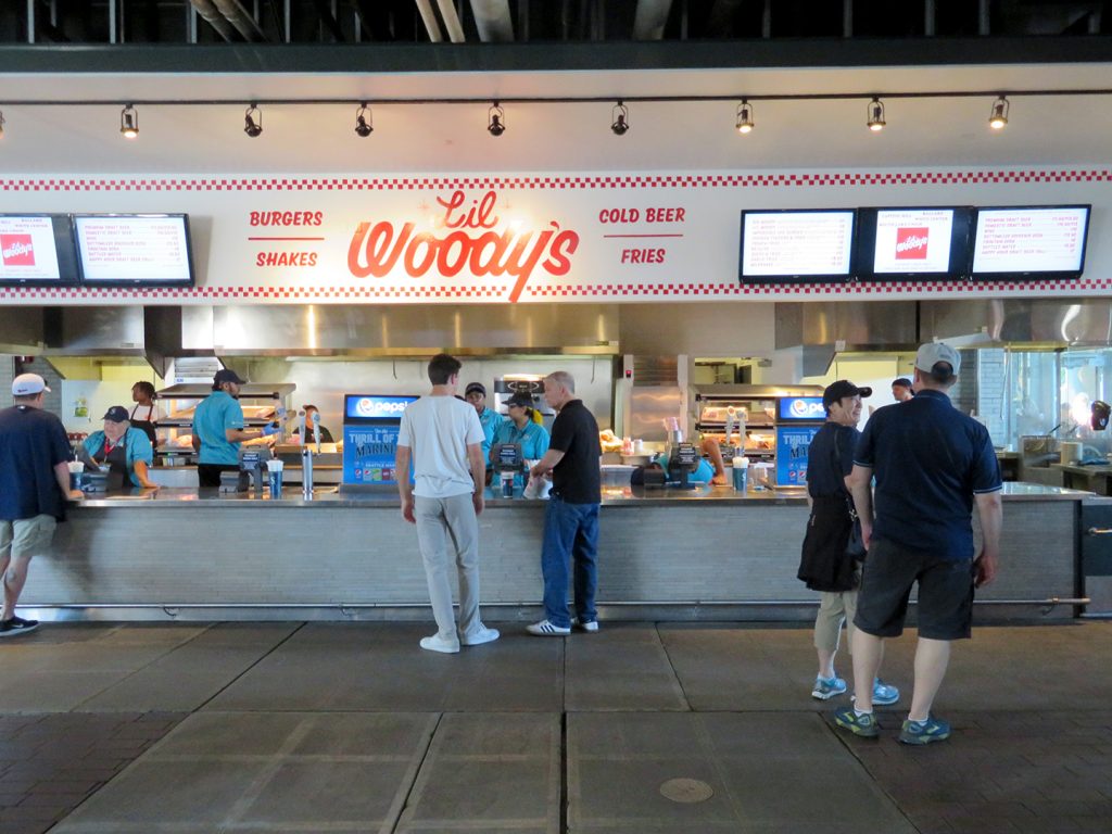 People stand in front of a Li'l Woody's concession stand.