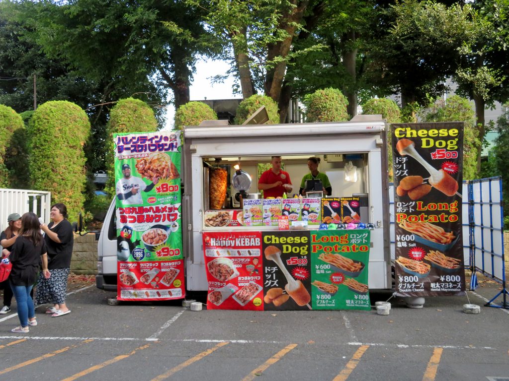 A small truck with a roll-up window operating as a concession stand.