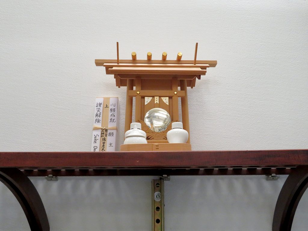 Small Shinto shrine atop a wooden shelf at SakéOne.