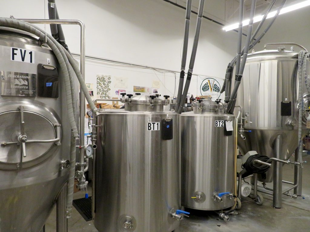 Pair of brite tanks sit between two larger fermentation vessels at Vertigo Brewing.