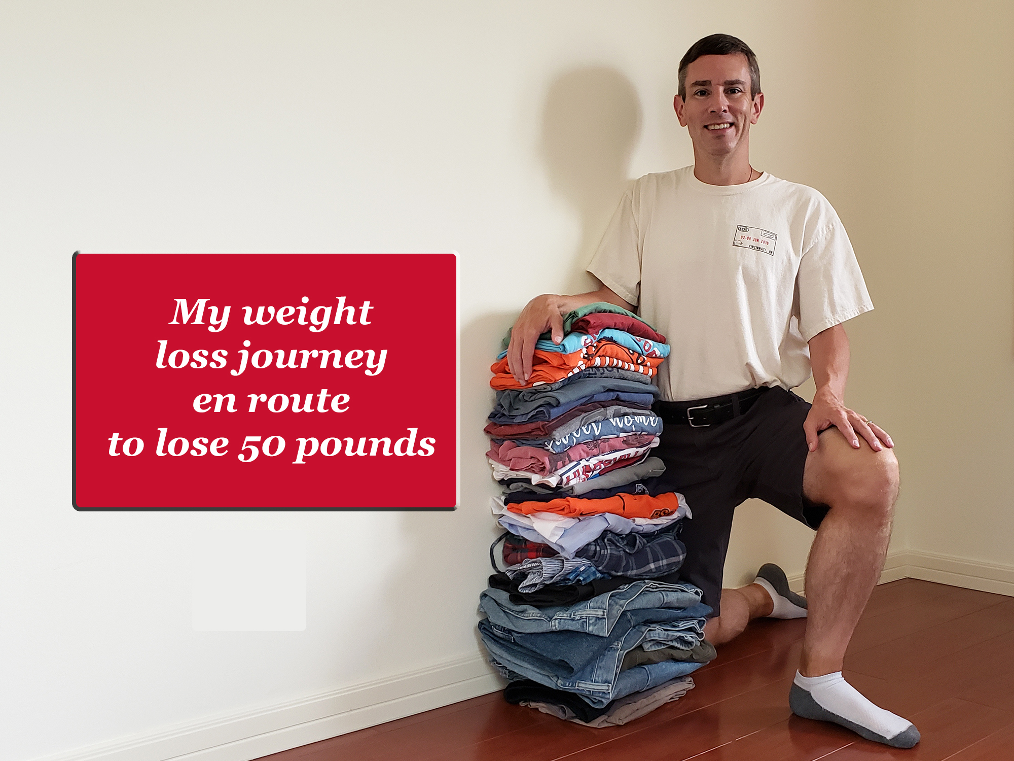 A man kneels next to a stack over-sized clothes with a text box to the left that says "My weight loss journey en rote to lose 50 pounds."